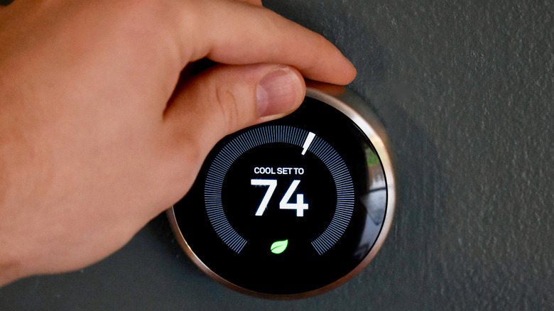 Someone adjusting temperature on Nest thermostat