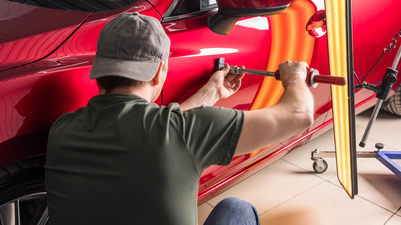 man fixing dent