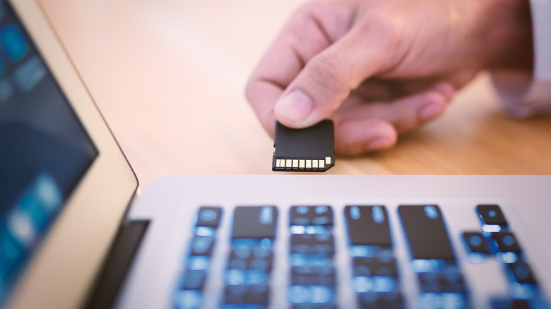 Person putting SD card into computer