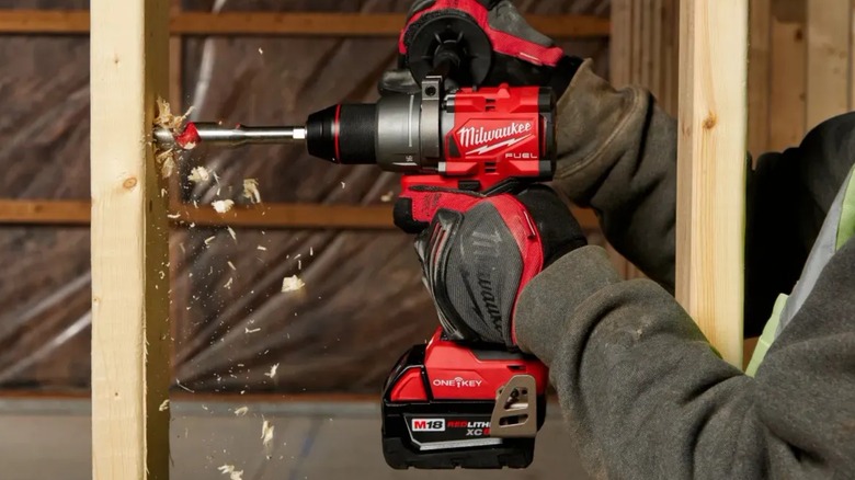 person using Milwaukee drill