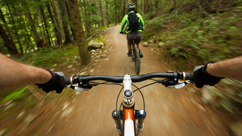 POV image of a mountain biker following another biker on a trail