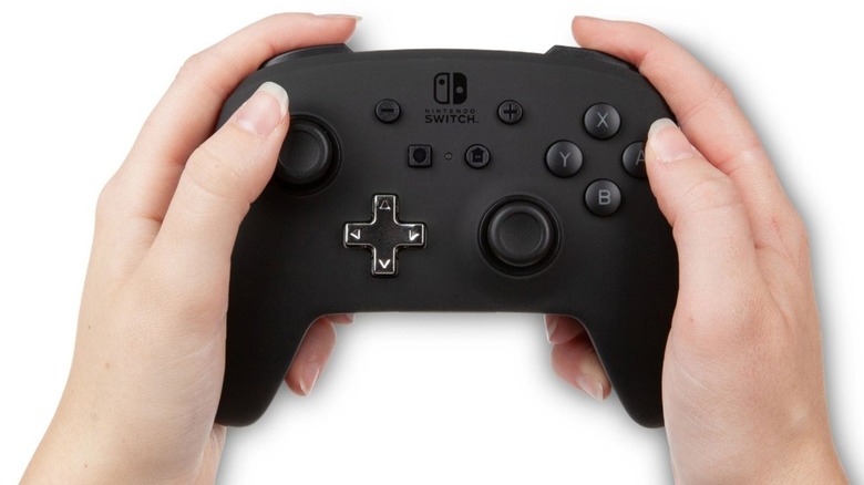 PowerA Enhanced Wireless controller held in a pair of hands.