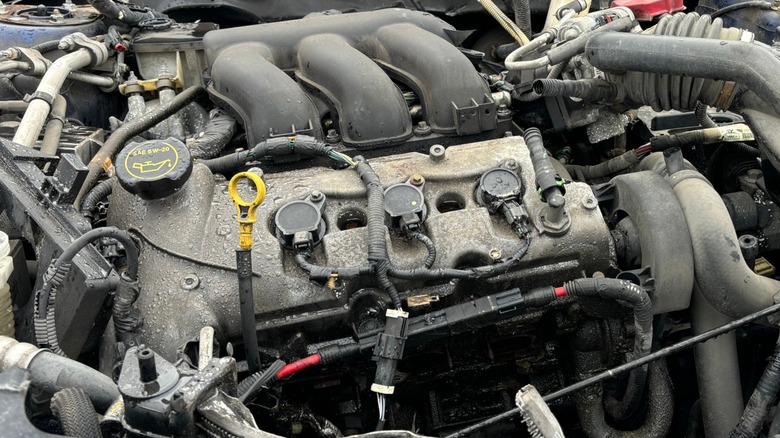 A used engine in a wrecked junkyard car.