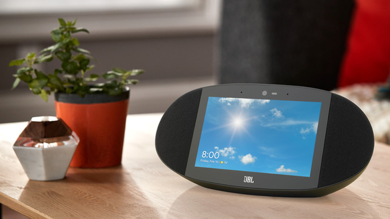 A JBL Link View showing weather predictions, on a table next to a small plant