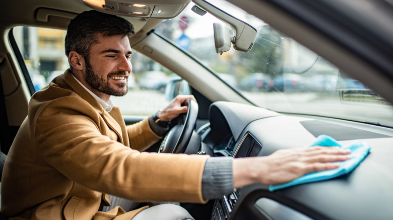 Man wiping car dashboard