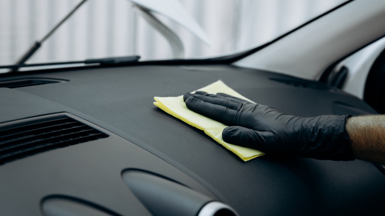 Wiping down dashboard with microfiber