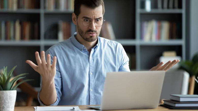 Annoyed man using laptop 