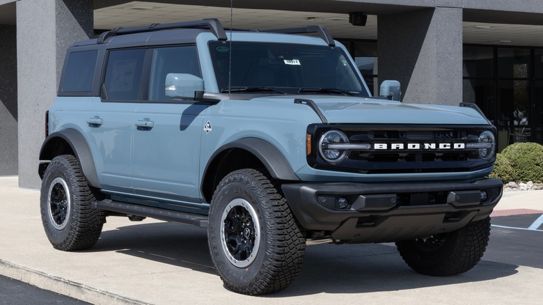 Blue Ford Bronco in front of a dealership