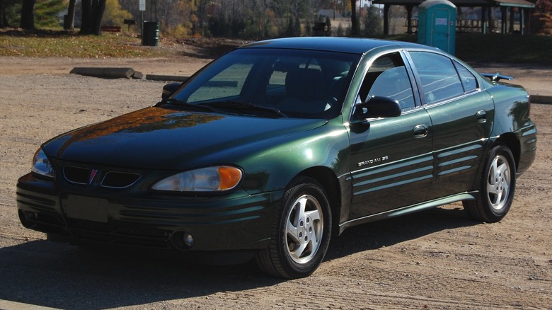 Dark green 2000 Pontiac Grand Am parked on dirt