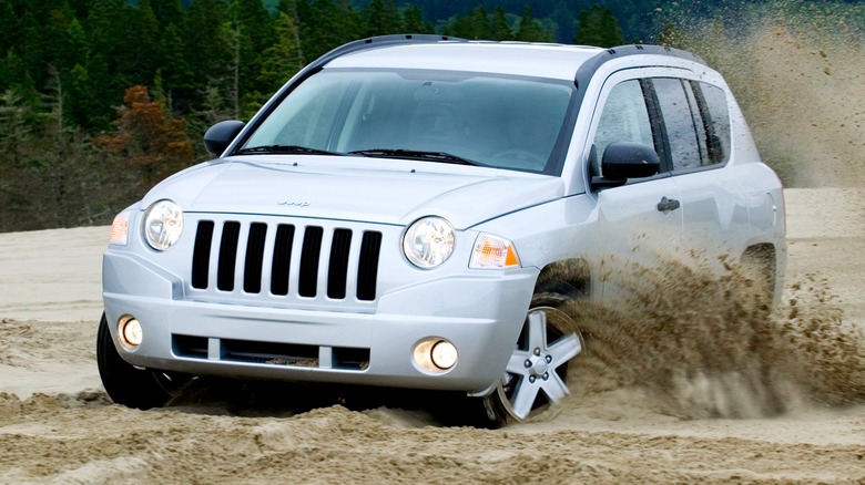 2009 Jeep Compass driving through the sand on a beach