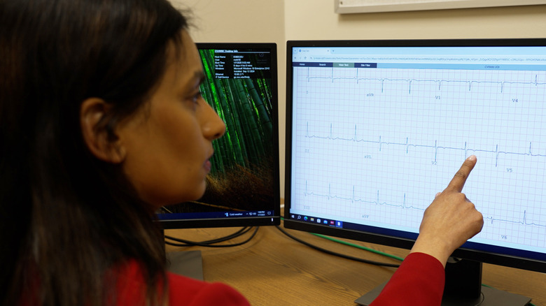 A doctor reading patient health records on a computer