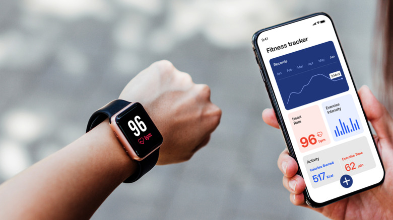 A person checking the data collected by a smartwatch on a phone