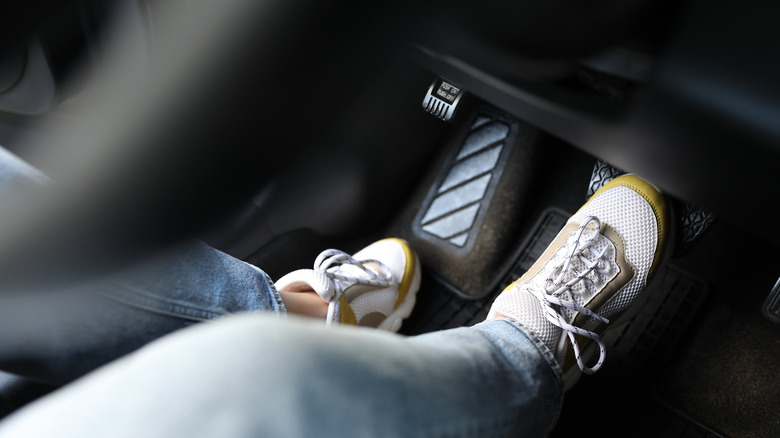 A driver stepping on a car's brake pedal