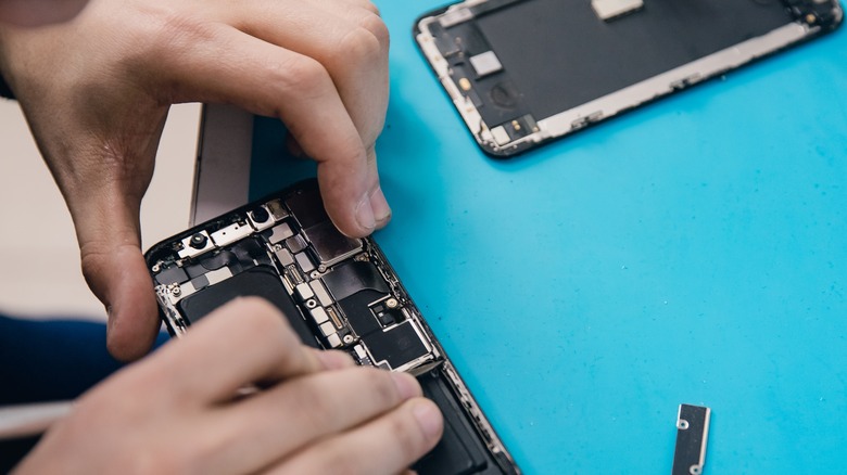 person disassembling broken phone