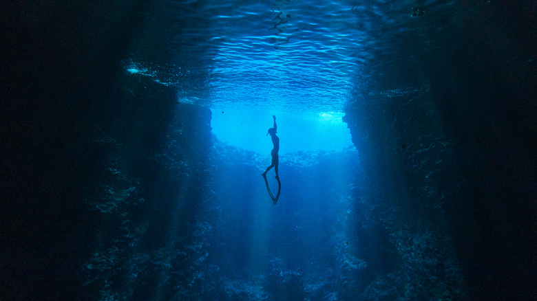 Diver in deep underwater trench