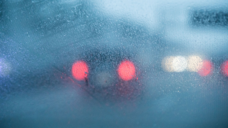 blurred photo of traffic through a foggy car windshield