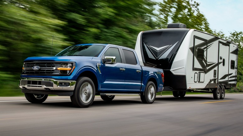 Blue Ford F-150 XLT towing on the road