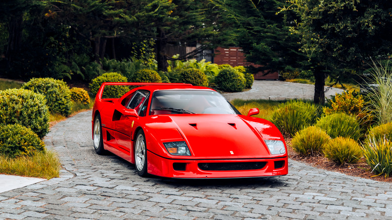 Red Ferrari F40 front 3/4 view with trees behind