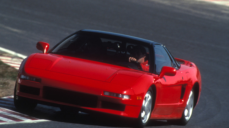 Red 1990 Acura NSX cornering at speed on a track