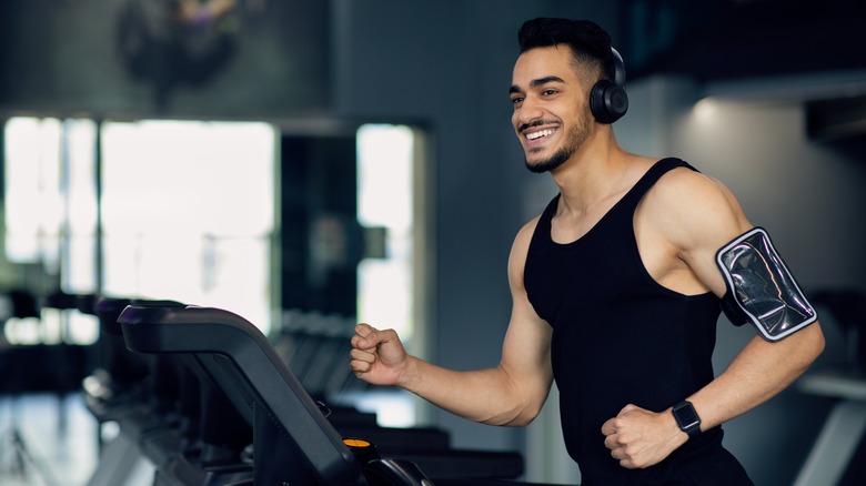 man running on treadmill with headphones