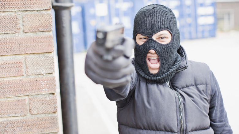 masked criminal pointing gun
