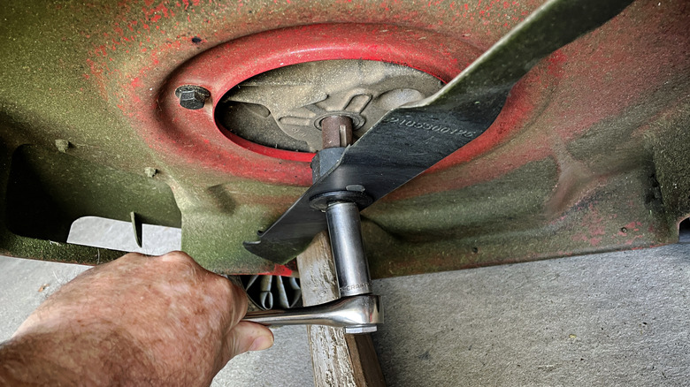 Person adjusting a mower blade