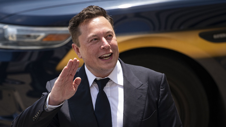 Elon Musk waving at people.