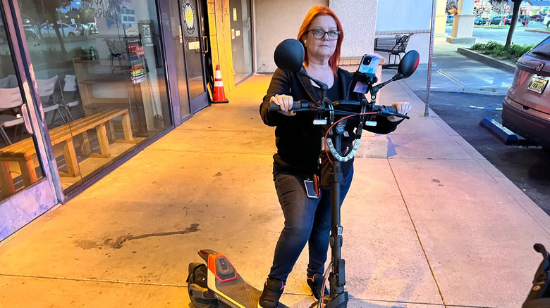 Woman with one foot on Segway P1000S scooter on city sidewalk