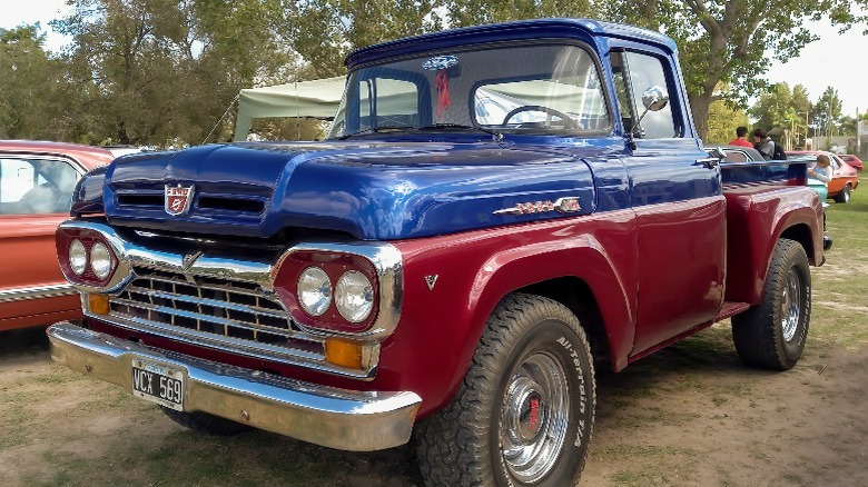 A picture of a red and blue third-gen Ford F truck 