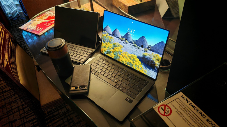 Windows 11 laptop on desk with smartphone, tablet, and power bank