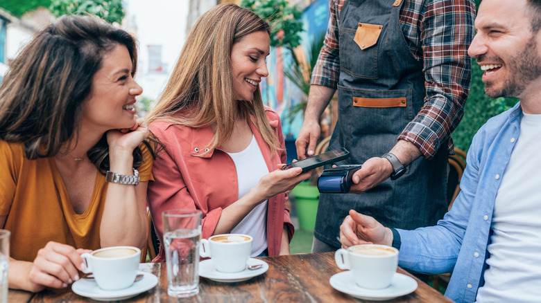 people eating paying with iphone