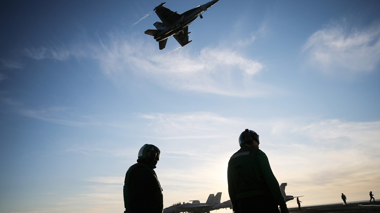 Growler flying over carrier crew