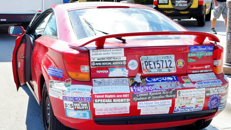 red car with bumper stickers