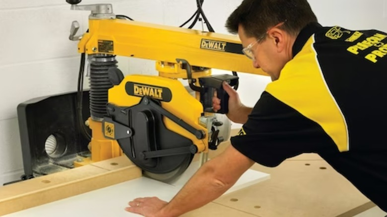 A person using a DeWalt radial arm saw.