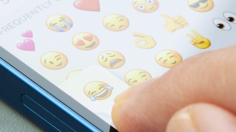 Person selecting emoji from iMessage menu