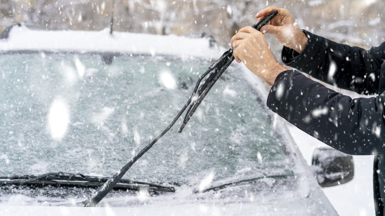 person inspecting wiper blades winter