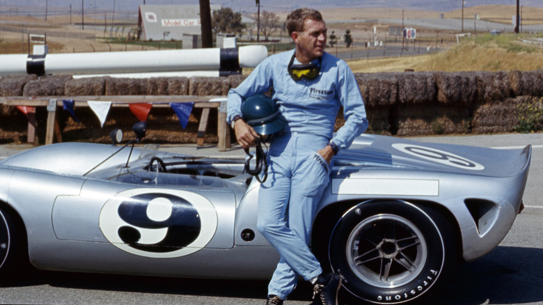 Steve McQueen leaning against a Lola T70