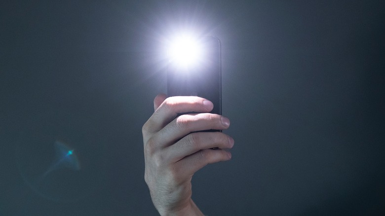 A phone's flashlight shining bright