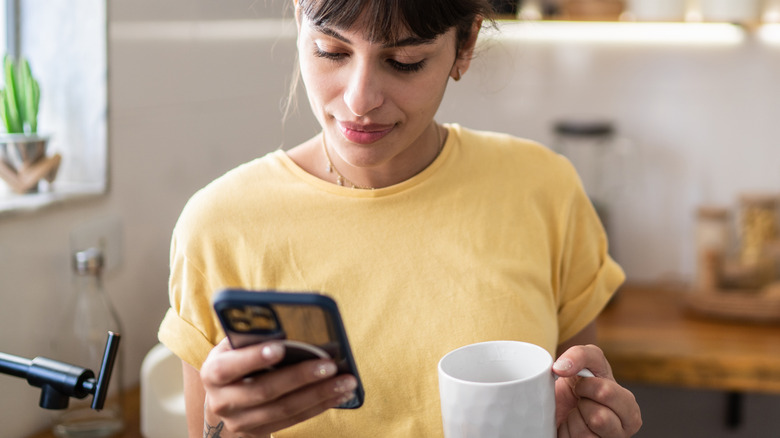 woman using iphone drinking tea