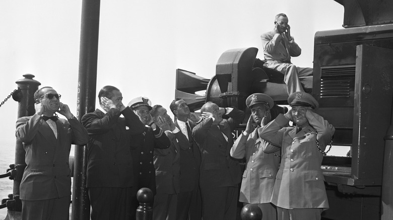 men holding their ears near the Chrysler Air Raid Siren