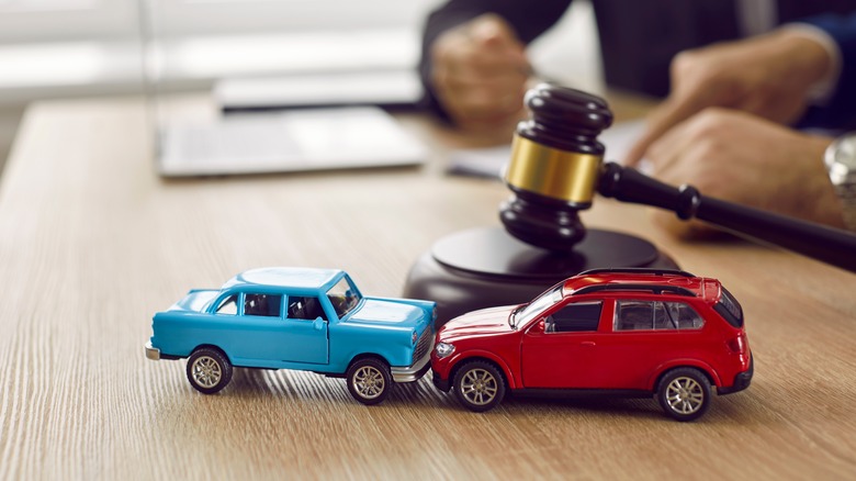 two crashing toy cars next to a gavel