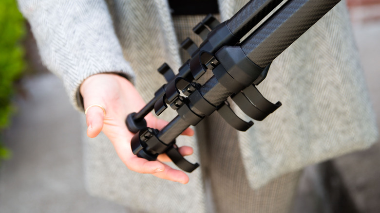 woman locking tripod legs