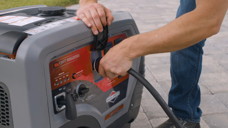 Plugging cord into Briggs & Stratton portable generator