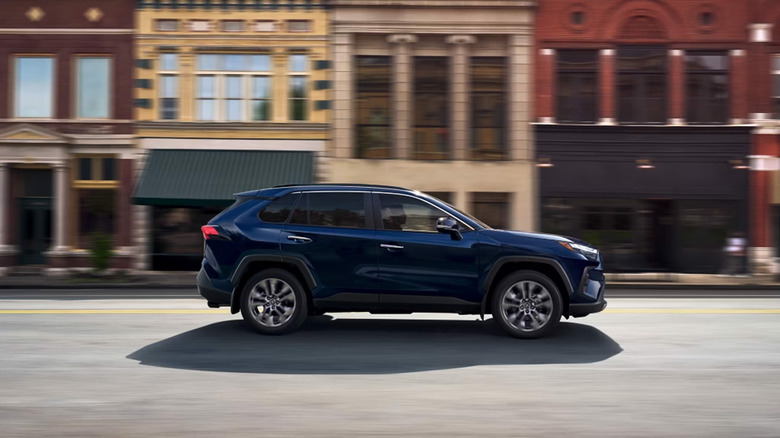 A blue Toyota driving down a city street