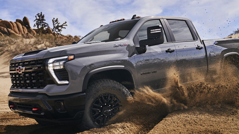 Silver 2024 Chevrolet Silverado HD ZR2 driving through dirt