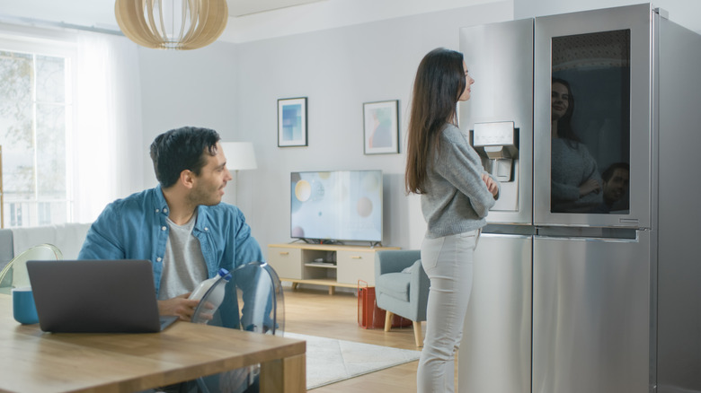 A couple looking at their smart refrigerator