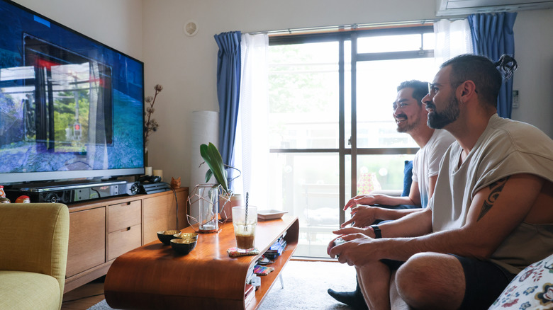 Men watching TV in their living room