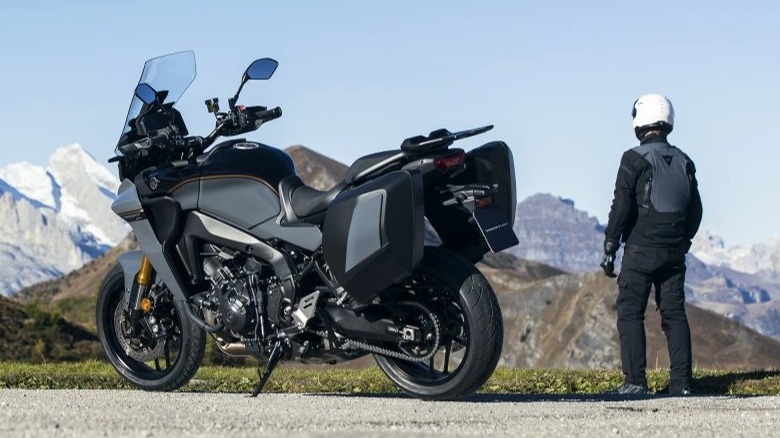 rider standing beside parked Yamaha