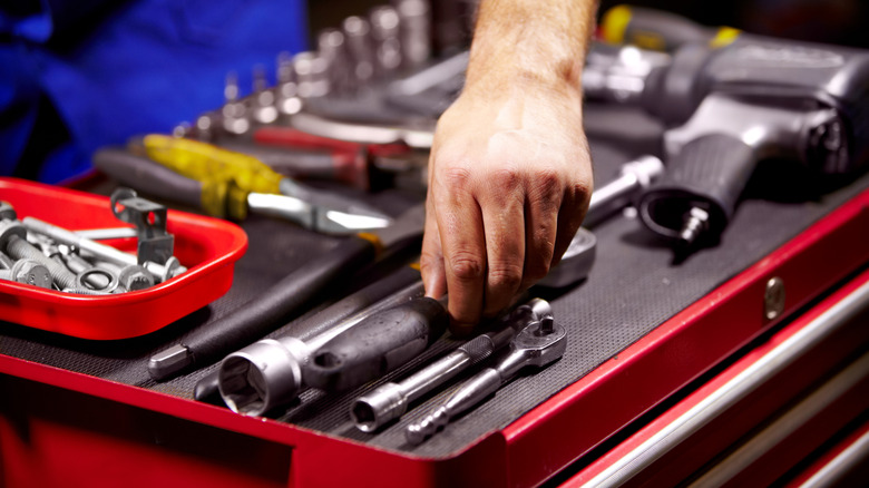 man selecting tool from case