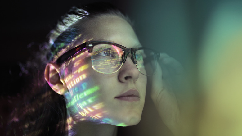 Woman with glasses examining code